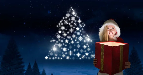 Kobieta trzyma magiczny dar i śnieżynka święta drzewa kształt świecące w nocy zimowych w Santa — Zdjęcie stockowe