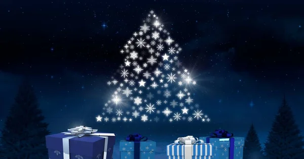Cajas de regalo y patrón de árbol de Navidad de copo de nieve brillando en el cielo nocturno de invierno — Foto de Stock