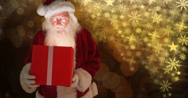 Санта держит подарок и рождественский узор Снежинки — стоковое фото
