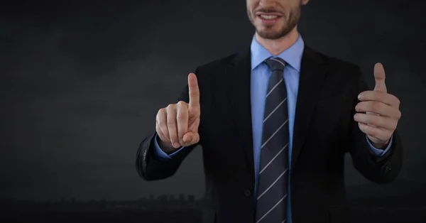 Businessman touching air with dark background — Stock Photo, Image