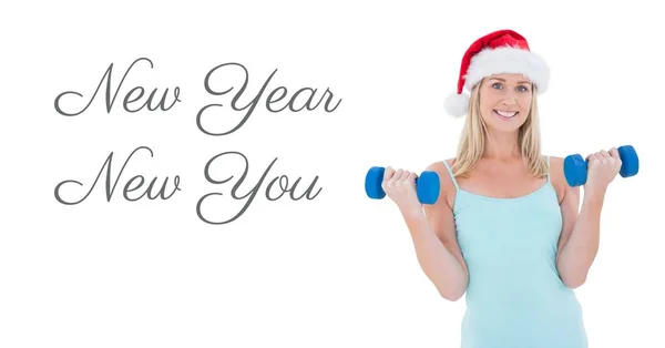 Woman lifting weights in Santa hat — Stock Photo, Image