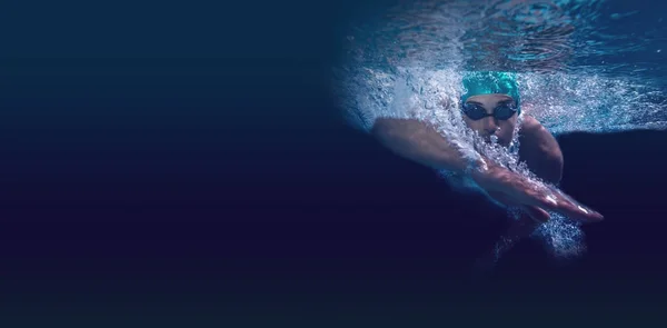 Een man die in blauw water zwemt — Stockfoto