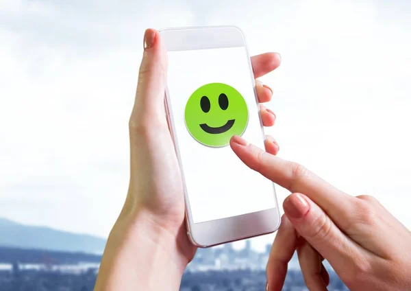 Digitales Zusammenspiel der Hand, die das Smiley-Gesicht auf dem Handy berührt — Stockbild Hand berührt Smiley-Gesicht am Telefon — Stockfoto
