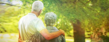 Güneşli bir günde bir parkta gülümseyen mutlu yaşlı çift