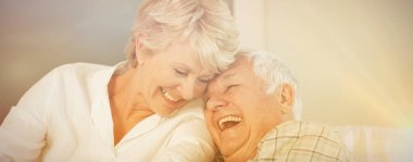 Cheerful senior couple laughing in bed at home clipart