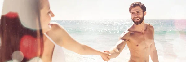 微笑对夫妇手牵着手在海滩 — 图库照片