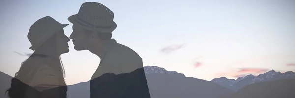 Ζευγάρι Ευτυχισμένο Hipster Περίπου Φιλί Ενάντια Χιονισμένα Βουνά Κατά Σούρουπο — Φωτογραφία Αρχείου