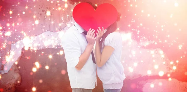 情侣用一颗心遮住他们的吻 对抗模糊的红光 — 图库照片