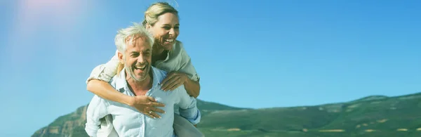 Man Giving His Laughing Wife Piggy Back Beach Sunny Day — Stock Photo, Image