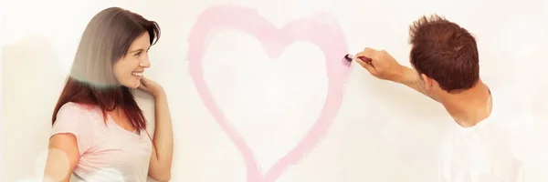 Mulher Bonito Olhando Para Namorado Pintando Coração Parede — Fotografia de Stock