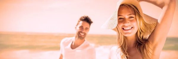 在海滩上牵着手的一对微笑的夫妇 — 图库照片