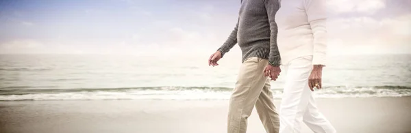 年配のカップルが手を繋いでいると うれしそうにビーチに歩いて — ストック写真