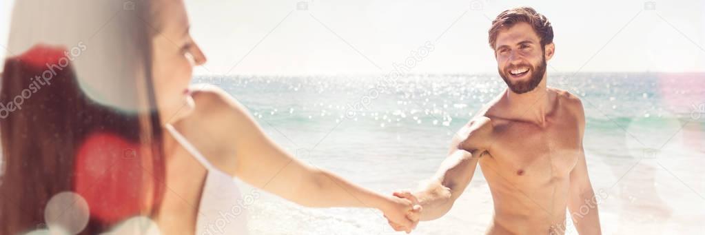 Smiling couple holding hands at the beach