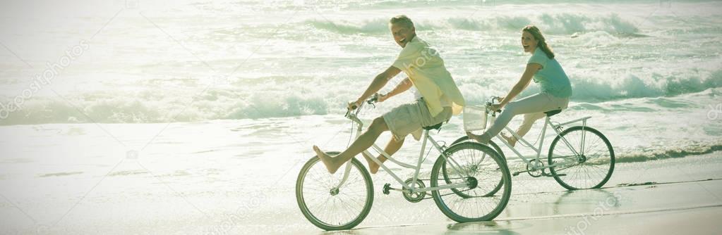Happy couple on a bike ride at the beach