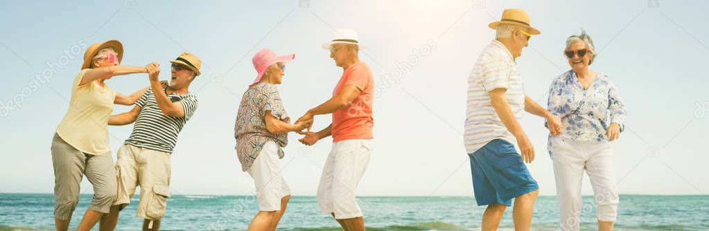 Happy senior couples dancing on shore at beach