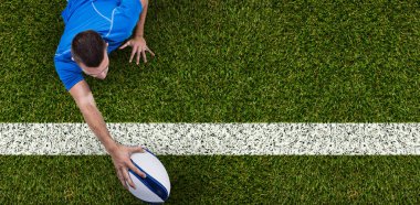 Rugby oyuncusu önünde yeşil kare beyaz çizgi ile top ile yalan arka görünümü
