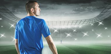 Rugby oyuncusu uzakta rugby stadyum karşı topu tutarken arıyorsunuz