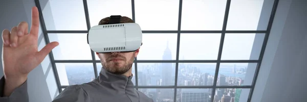 男子手势 而使用虚拟现实耳机对房间大窗口显示城市 — 图库照片