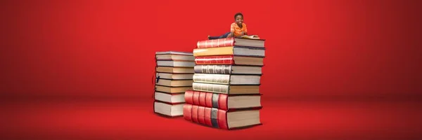 Composto Digital Boy Lendo Uma Pilha Livros Com Fundo Vermelho — Fotografia de Stock