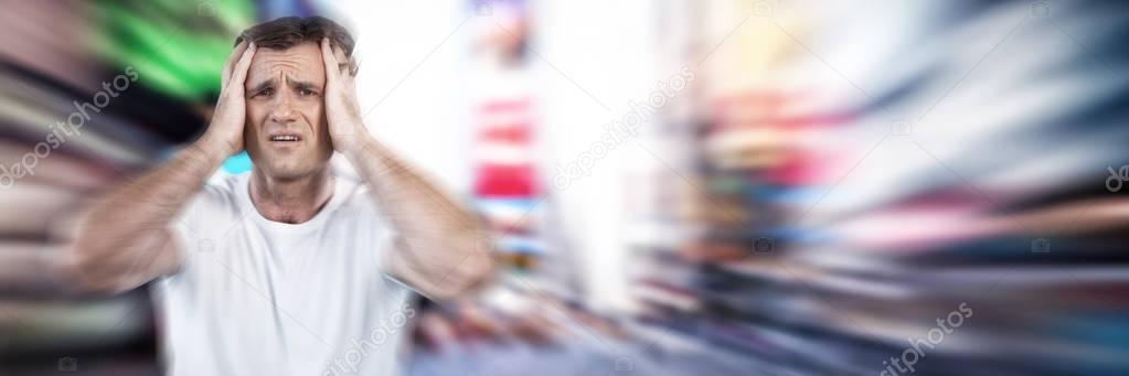 Frustrated mature man with head in hands against blurry new york street