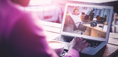 Gülümseyen işadamı sandalyeye rahatlatıcı karşı kafede dizüstü bilgisayar kullanan kadın