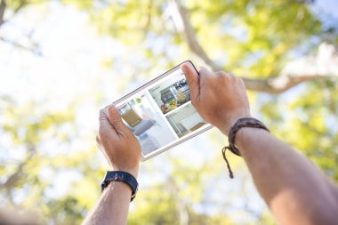 Grafik görüntü kırpılmış eller dijital tablet kullanarak karşı ev iç