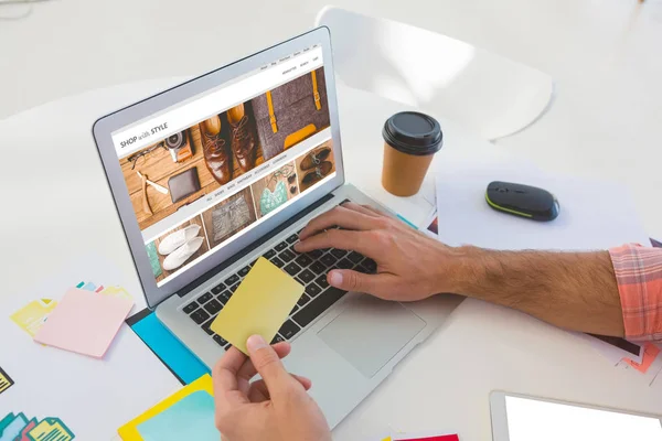 Stil ana dizüstü bilgisayar kullanırken erkek grafik tasarımcı holding yapışkan notun kırpılmış eller karşı ile alışveriş