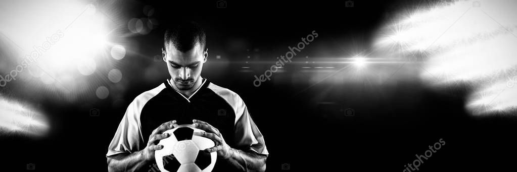 Player looking at football against view of spotlights