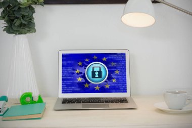 Laptop ve Avrupa Birliği bayrağı emniyet konsepti ile karşı masada çeşitli ofis aksesuarları
