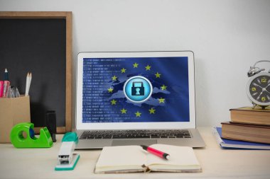 Laptop ve Avrupa Birliği bayrağı emniyet konsepti ile karşı masada çeşitli ofis aksesuarları