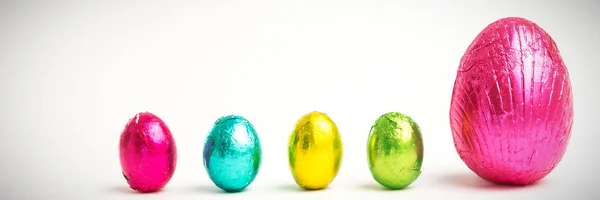 Cuatro Pequeños Huevos Pascua Junto Uno Grande Envuelto Papel Colores —  Fotos de Stock