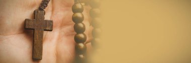 Close-up of hand holding rosary beads clipart