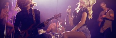 Kadın şarkıcı ve birlikte gece kulübünde sahnede performans tousled saçlı erkek gitarist