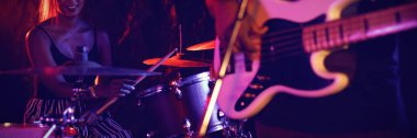 Kadın davulcu gitarla gece kulübünde oynayan adam orta bölümünde
