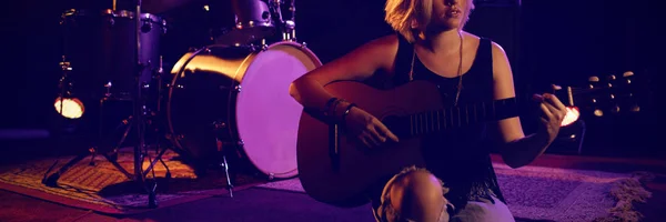 Vrouwelijke Beoefenen Gitaar Zittend Het Podium Nachtclub — Stockfoto