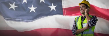 Buruşuk Amerikan bayrağı tam kare karşı telefonda gülümseyen inşaat işçisi