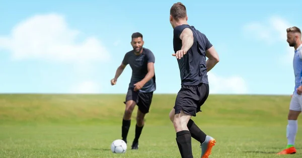芝生の上のフットボールを蹴るサッカー選手のデジタル合成 — ストック写真