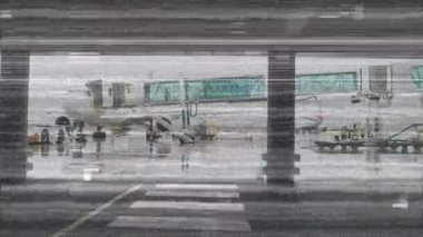 Havaalanı çalışanlarının ve uçakların, ön planda yatay beyaz çizgileri ve kareleri olan yolcular için hızlı hareket halinde olduğu animasyon.