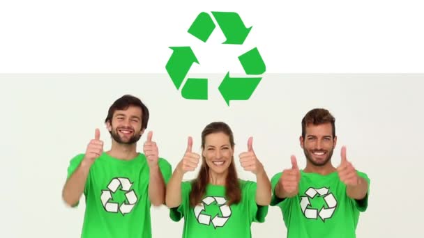 緑のTシャツを着てリサイクルサインをしたり 笑顔で親指を立てたり 白い背景にリサイクルサインをしたりする若い多民族の男性と女性の友人のグループのアニメーション — ストック動画