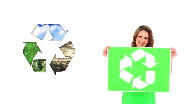 リサイクルサインのある緑のTシャツを着た若い白人女性のアニメーション リサイクルサインのある緑の看板を彼女の隣に置きます — ストック動画