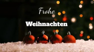 Beyaz harflerle yazılmış Frohe Weihnachten kelimelerinin animasyonu. Noel ağacı ve arka planda kırmızı mücevherler.