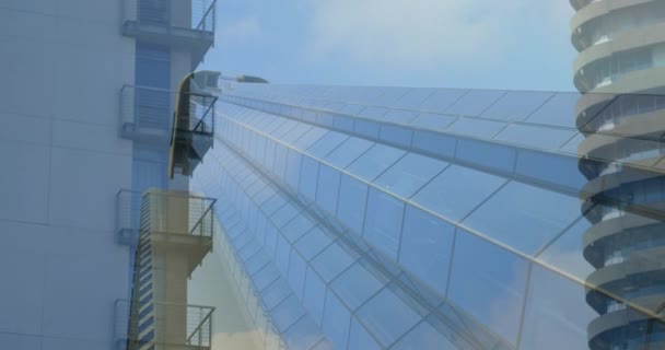 背景に青空を背景に都市の近代的な建物を移動するアニメーション4K — ストック動画