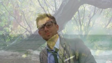 Ön planda çiçeklerle kameraya gülümseyen genç beyaz adamın animasyonu