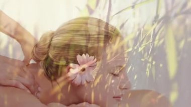 Ön planda hareket eden çimlerle masaj yaptıran mutlu beyaz kadın animasyonu.