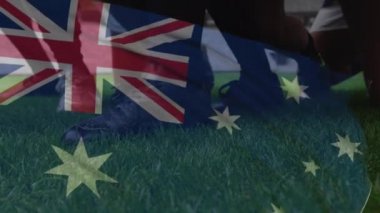Avustralya bayrağının bir ragbi topunun üzerinde sallanmasının animasyonu çimenler ve bir spor stadyumu üzerinde yuvarlanıyordu.