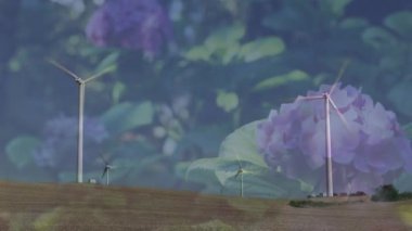 Ön planda çiçeklerle rüzgar türbinlerini döndürmenin animasyonu