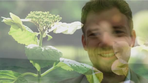 Planda Çiçeklerle Kameraya Gülümseyen Genç Beyaz Adamın Animasyonu — Stok video