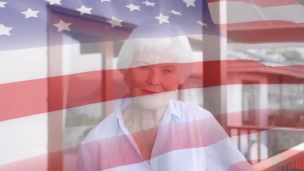 前景にアメリカ国旗が振ってあるカメラを見る白人女性のアニメーション — ストック動画