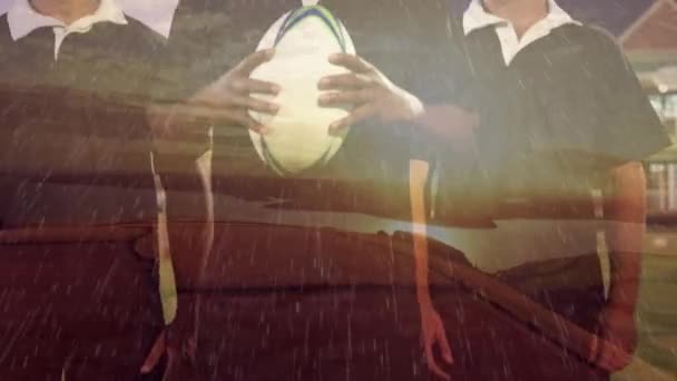 Animacja Trzech Graczy Rugby Stojących Stadionie Deszczu Trzymających Piłkę Patrzących — Wideo stockowe