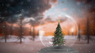 Noel kar küresi animasyonu. İçinde Noel ağacı ve arka planda köknar ağaçlarının üzerine düşen kar.